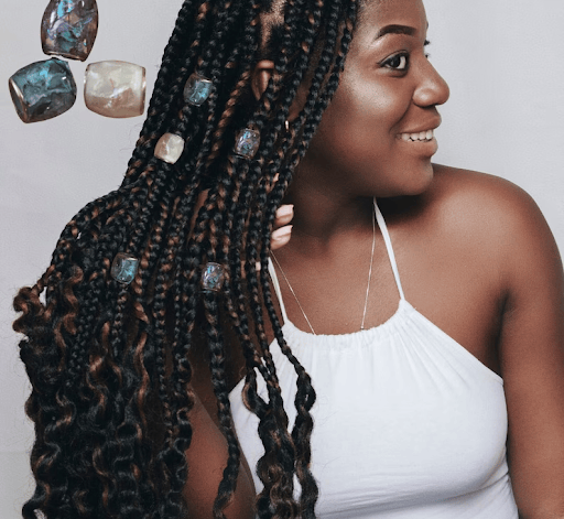 Woman with box braids displaying her jewel hair beads.