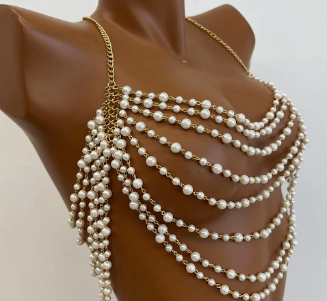 A chest piece made of many strings of pearls on gold chains.