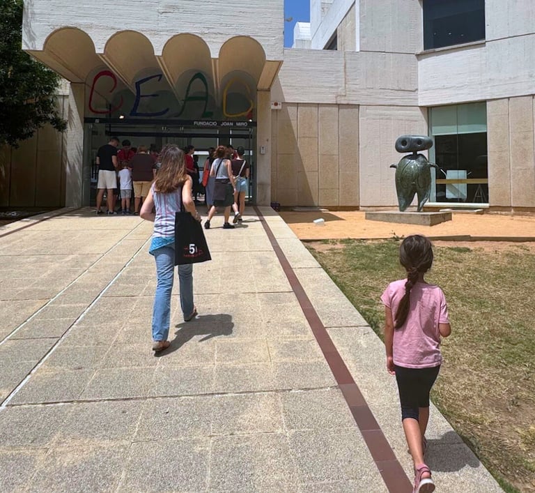 a woman walking with a child toward Barcelona Joan Miro museum