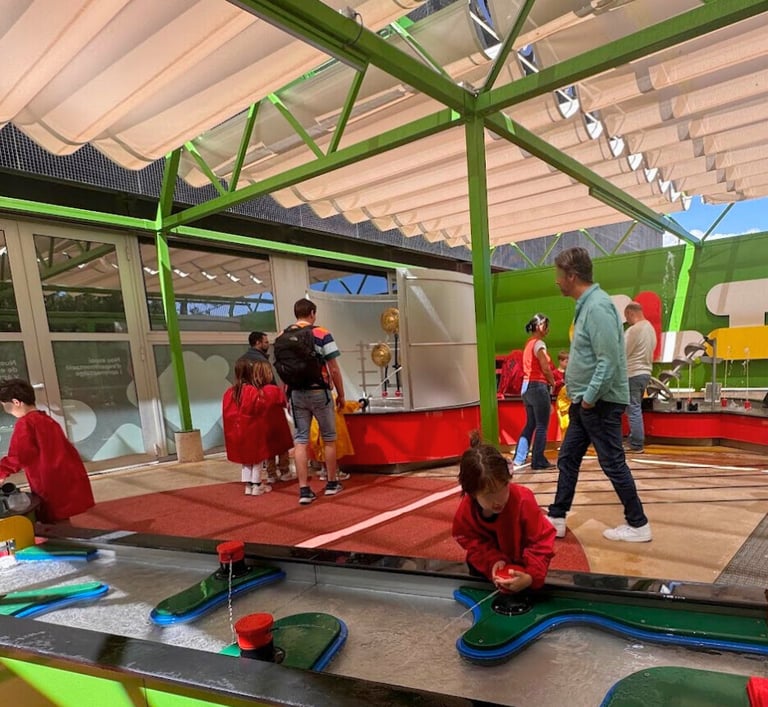 young kids playing with water toys in a Clik play area at CosmoCaixa museum in barcelona
