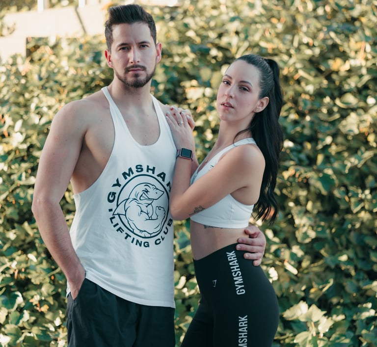 "Pareja heterosexual de novios posando con ropa de gimnasio, mostrando su complicidad y estilo."