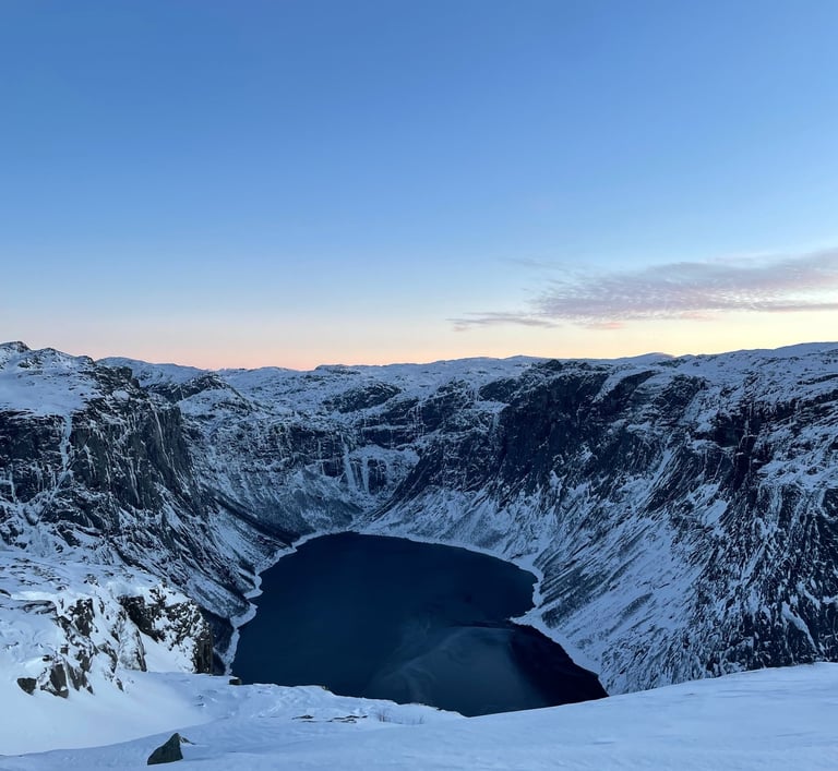 Frozen alpine lake in the Norway Alps, surrounded by snow-covered mountains and winter landscapes