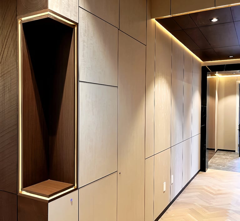 Modern hallway interior featuring cream wall panels, recessed LED lighting, and light oak herringbone flooring.