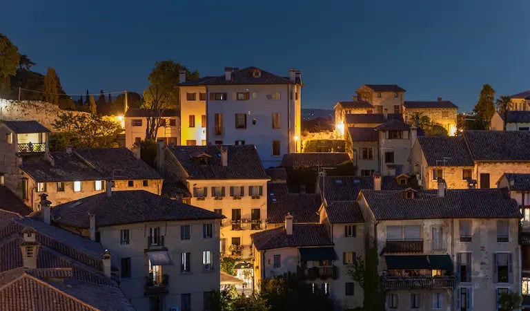 Evening view of a village in the Prosecco Hills, Veneto, with warm lights and historic rooftops