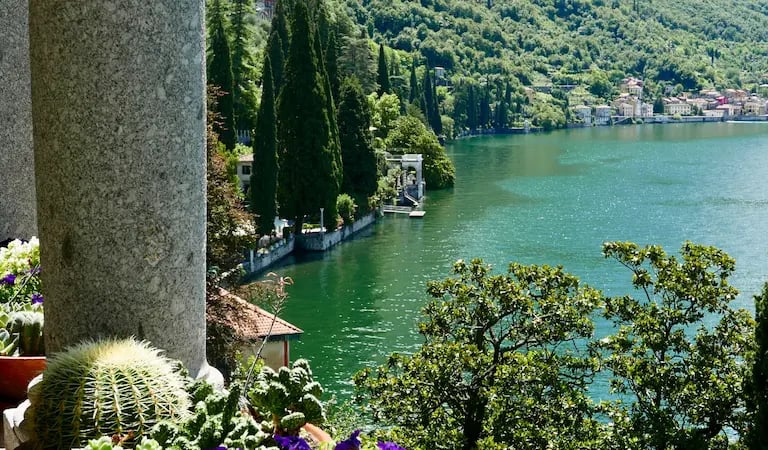 Scenic view of Lake Como with blue water, surrounding mountains, and Italian villas on the shore