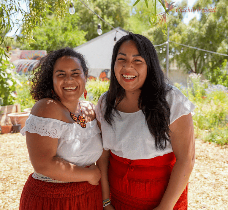 Iveth Balanta and Victoria Flores in red skirts and white blouses