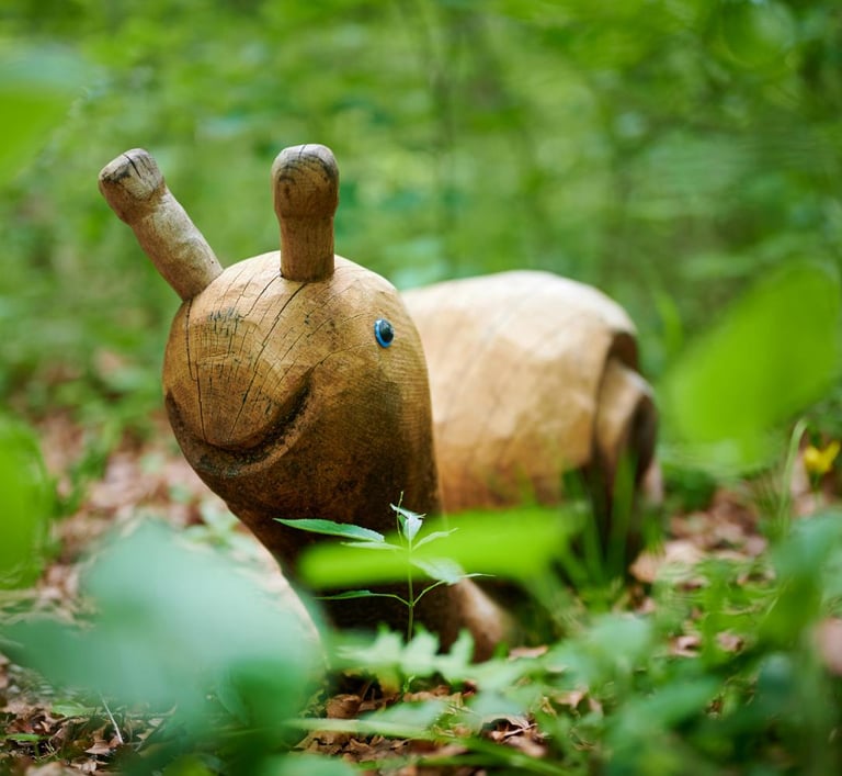a wooden toy elephant in the woods