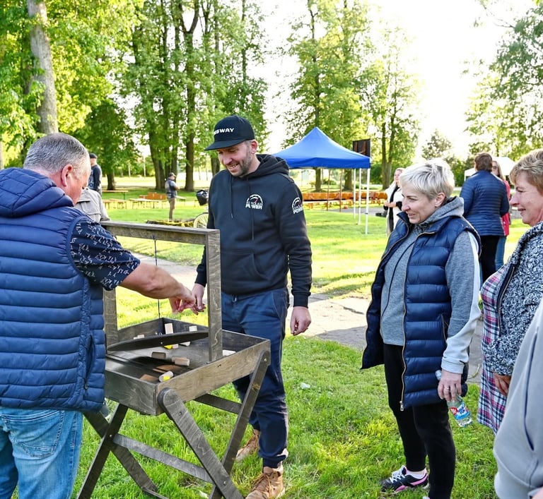 Balansinis žaidimas nuoma įmonės renginiui – kolegos žaidžia medinį lauko pusiausvyros žaidimą parke