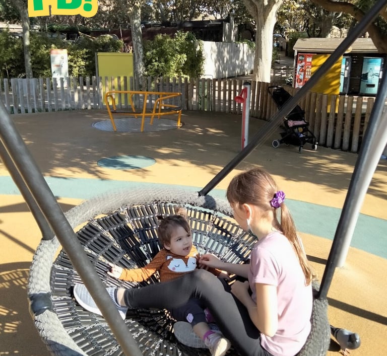 two young girls sitting on a swing - frame