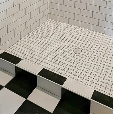 a bathroom with a black and white tiled floor