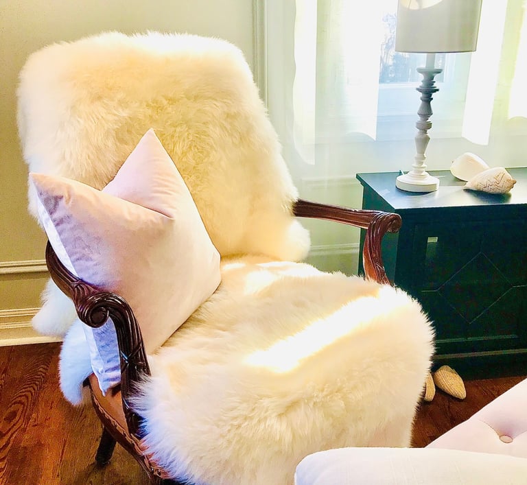 traditional chair with sheepskin and pink cushion