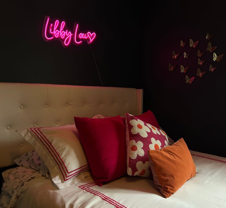 a bed with a neon sign that says hello to you
