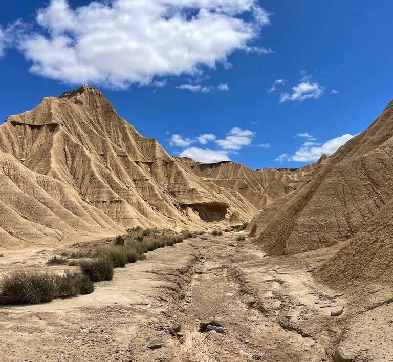Paisaje en perspectiva desde el fondo de un barranco seco en Piskerra, rodeado de altas formaciones 