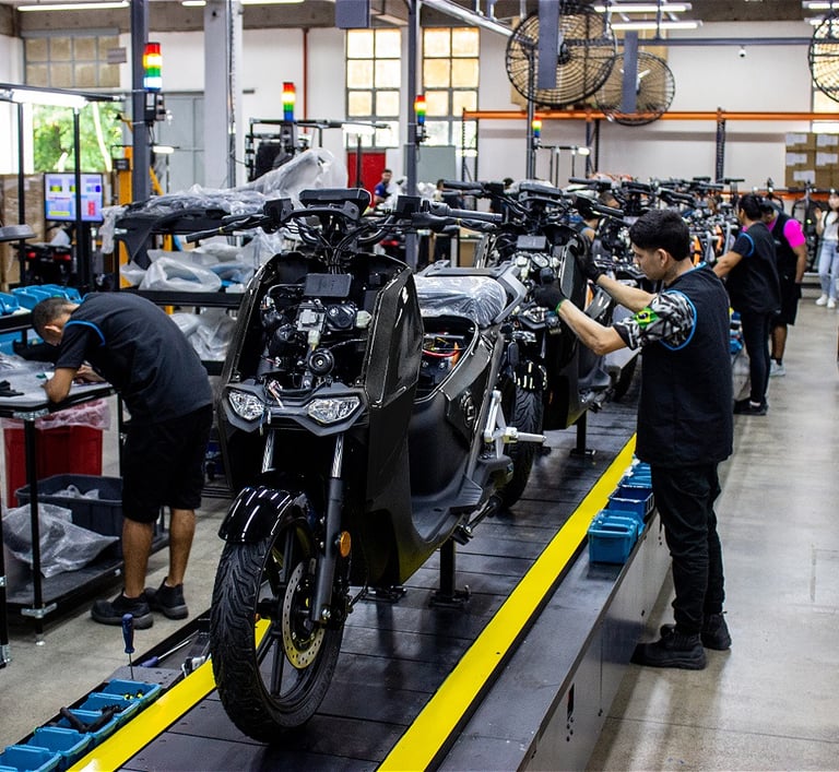 a man working on a motorcycle in a factory