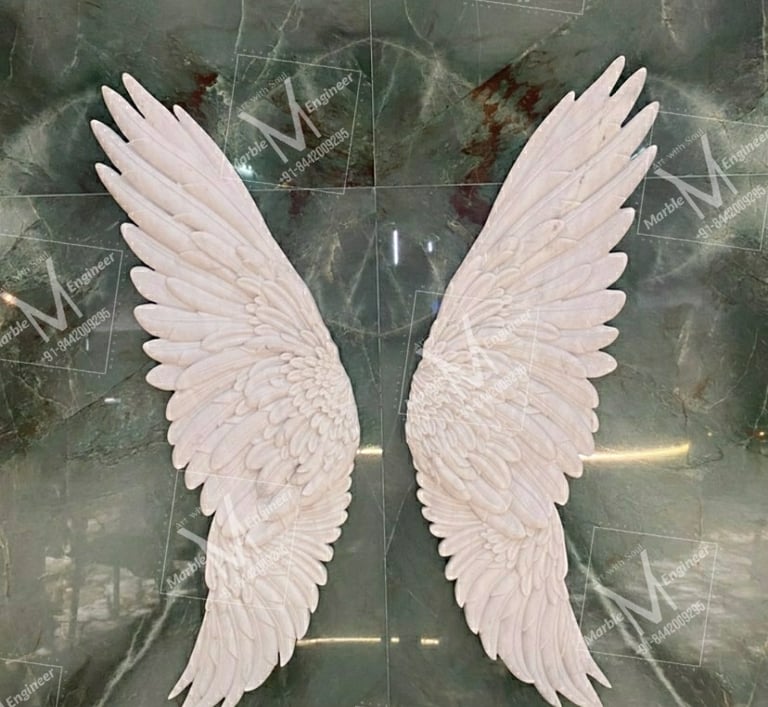 two white angel wings on a marble table