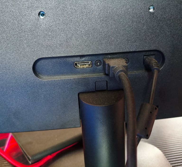 Detalhe das portas de conectividade traseiras do monitor AOC Q27B35E com cabos HDMI e de alimentação