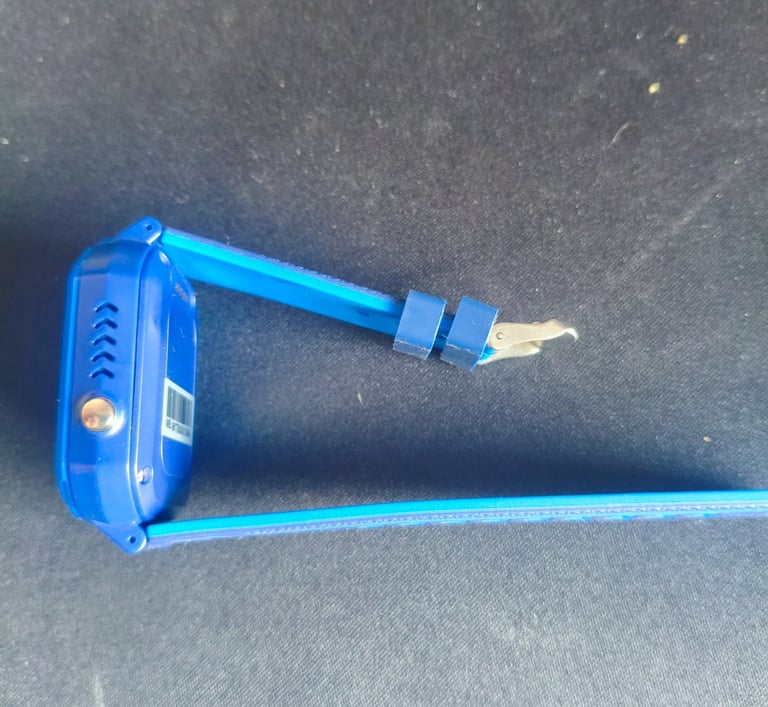 Análise de espessura lateral e botão SOS em smartwatch infantil azul com bracelete de silicone.