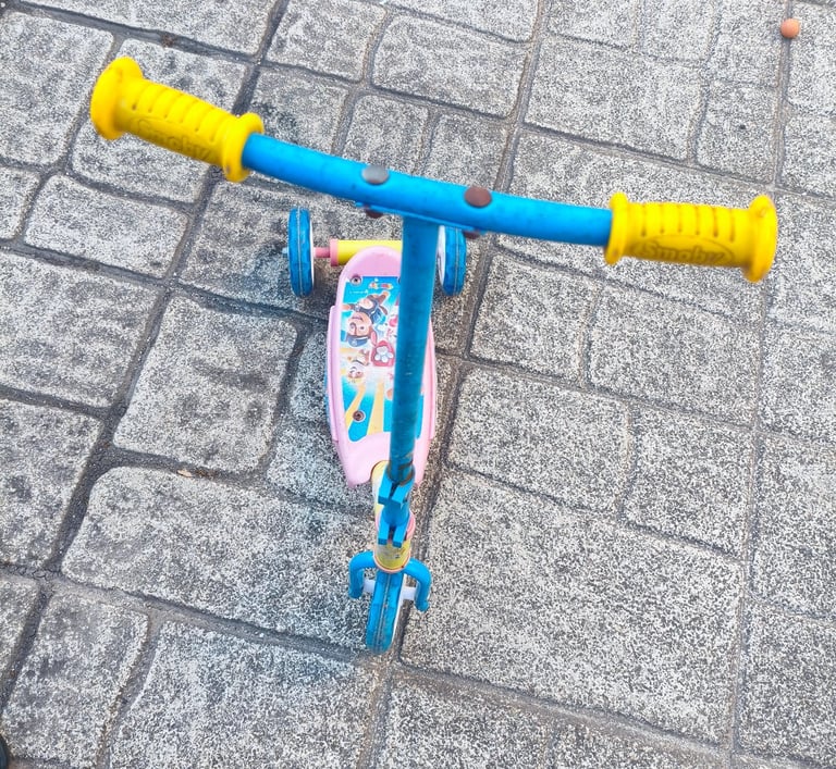 Vista de cima da trotinete Paw Patrol Smobe com guiador amarelo e azul e plataforma rosa com persona