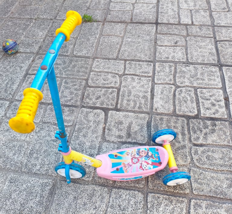 Trotinete 3 rodas Paw Patrol Smobe em azul e rosa em uso exterior com calçada portuguesa ao fundo