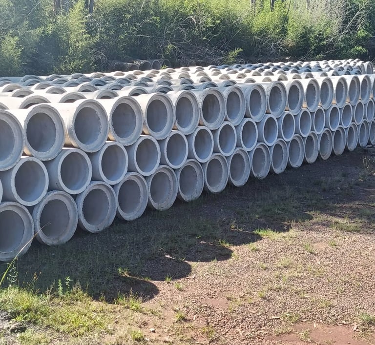 Stacked concrete drainage pipes for civil engineering and infrastructure projects outdoors.