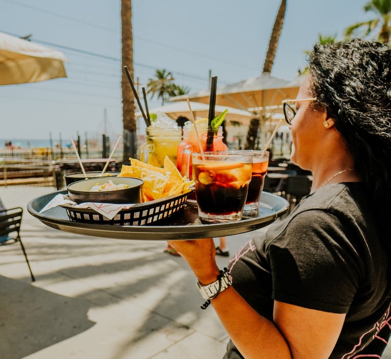 Waitress serving drinks and nachos on the terrace at Santa Lola Badalona