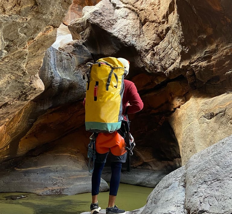 a person with a backpack on a rock formation