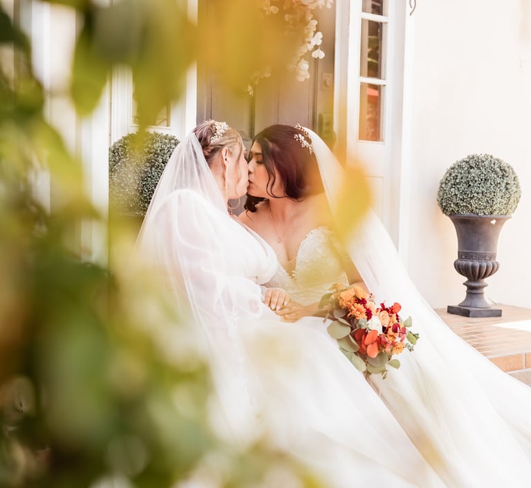 a bride and groom kissing on the porch