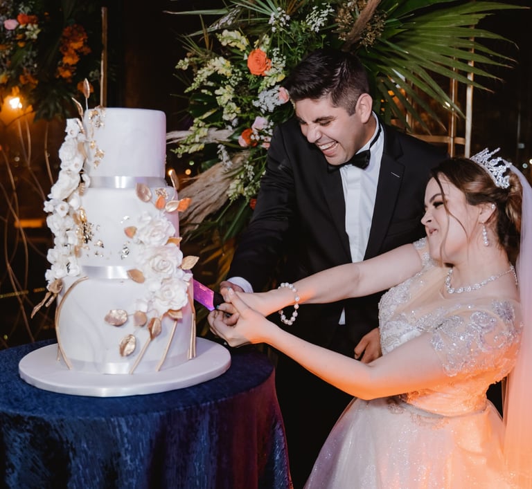 a bride and groom cutting their wedding cake
