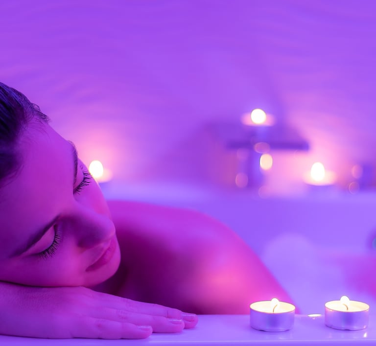 Close up Low light portrait of young woman relaxing in foam bath.Low colorful candlelight ambient wi