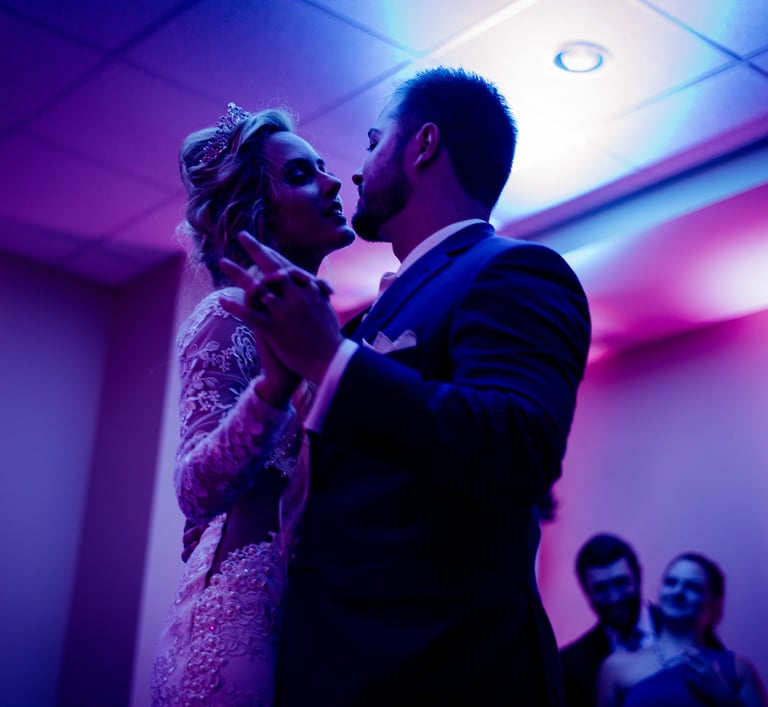 a bride and groom share a kiss at their wedding reception DJ