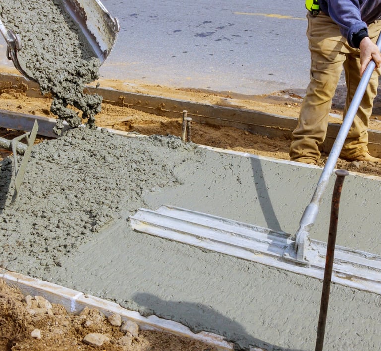 a man is pouring concrete into a concrete slab