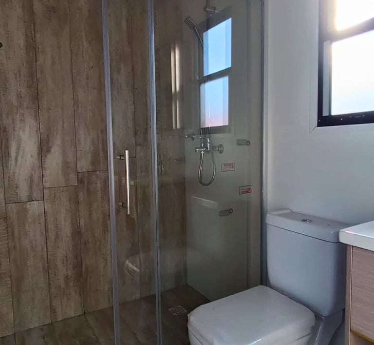 baño, mampara de vidrio e inodoro