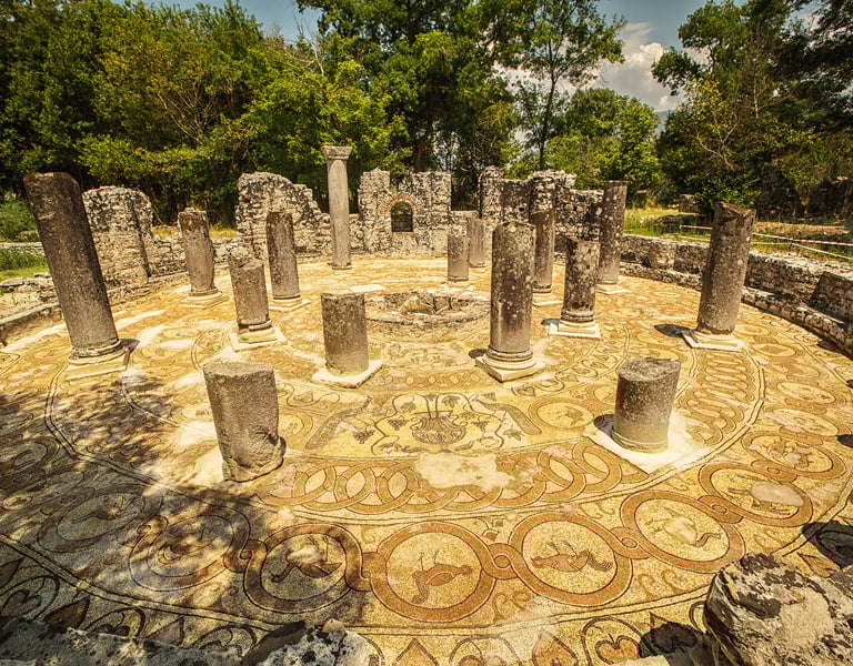 a circular stone mosaic tile flooring with a circular mosaic design