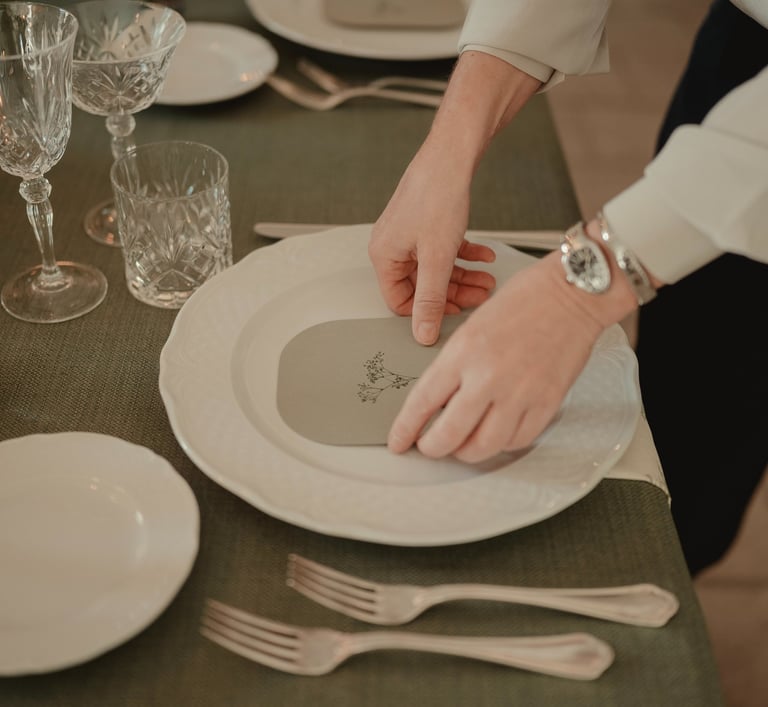 a person is setting a table with a plate of food