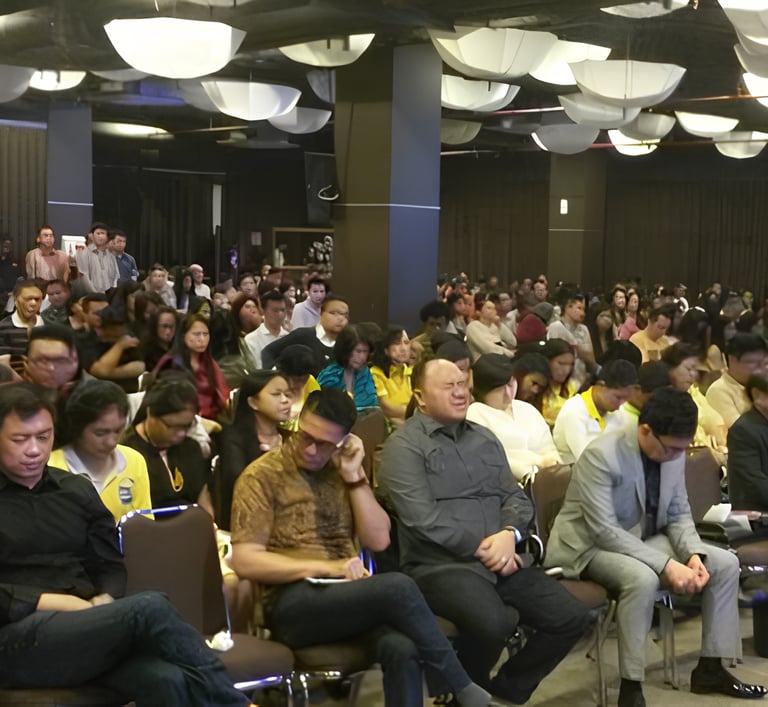 a large group of people sitting in chairs in a room