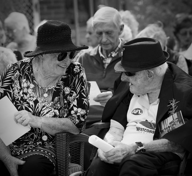 Elderly couple at AnZac Day event reminiscing.