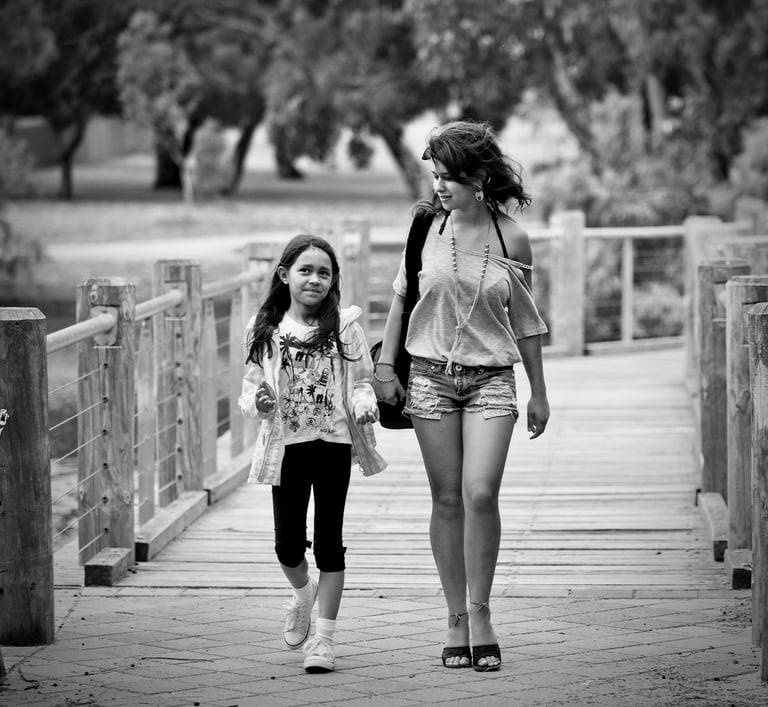 Young woman and child waling over a wooden bridge