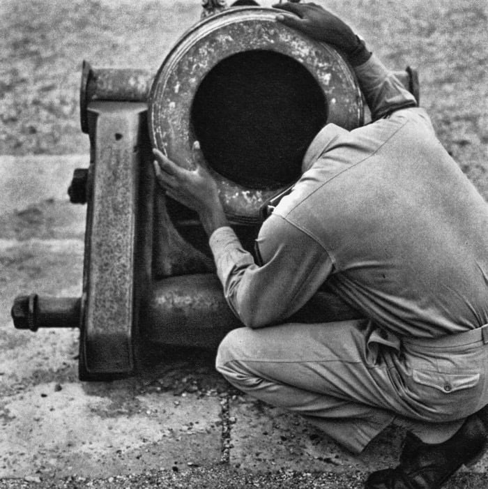 Man with afro looking into cannon