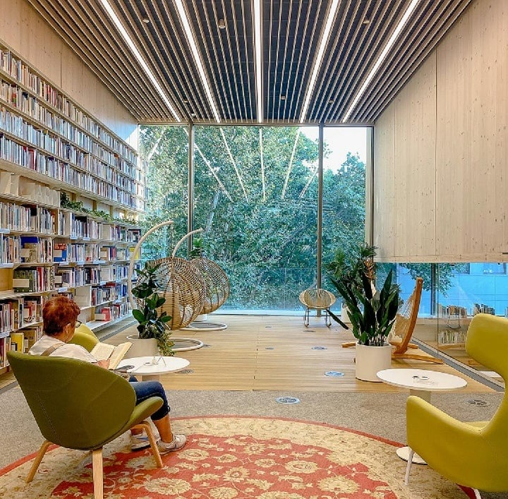 Espacio interiores de una biblioteca en la que se aprecia una persona leyendo