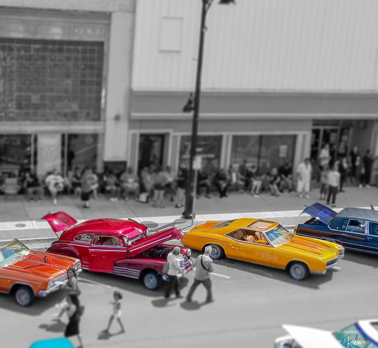 Colorful classic cars parked along a city street, with pedestrians and buildings shown in black and white.
