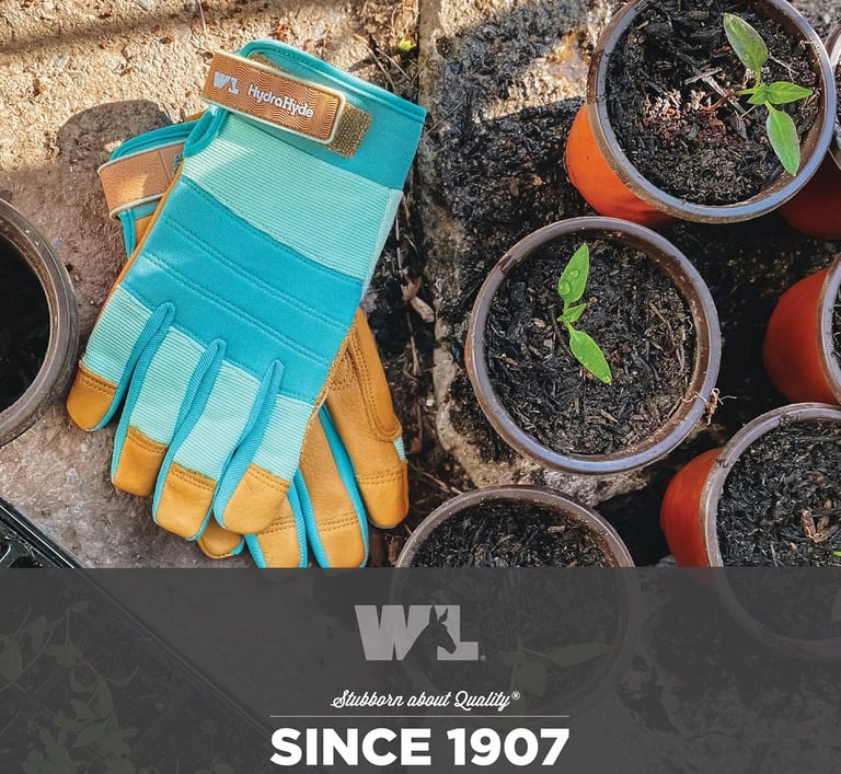 HydraHyde leather gardening gloves next to small potted seedlings in a sunny garden setting.