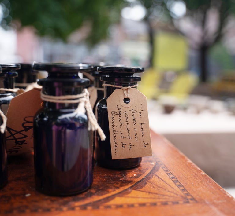 Apothocarie bottles with twine and handwritten notes on top of a wooden table in a park