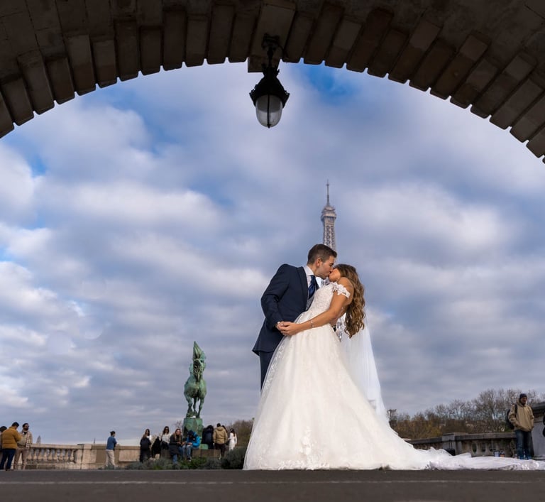 "Pareja heterosexual casada besándose bajo la Torre Eiffel en París, celebrando su amor y unión."