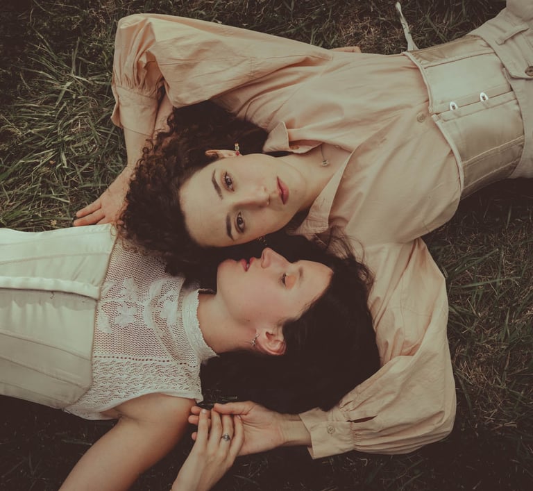 "Pareja lesbiana vista desde arriba, abrazándose en el suelo, celebrando el amor en una boda gay."