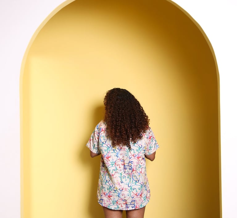 a woman standing in a doorway with a yellow wall