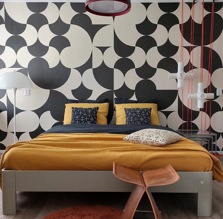 a bed with a yellow bed and a red rug designed by house of akaya India