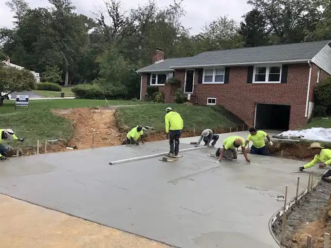 a group of men in yellow jackets and yellow jackets working on a concrete slab