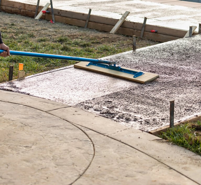 a person using a broom to clean a sidewalk
