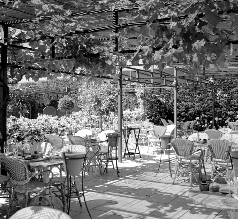 Terrasse ombragée du restaurant Le Cipressa au cœur de la Maison.