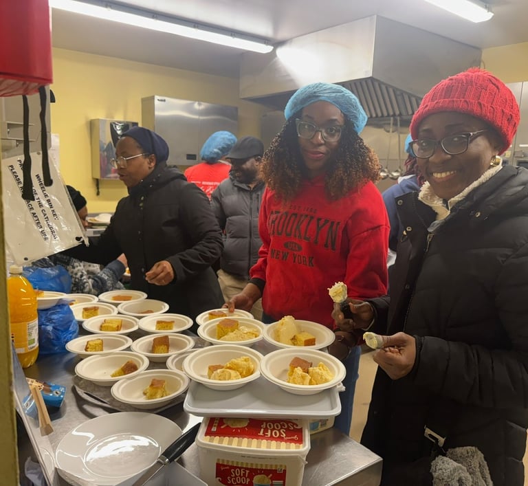 Smiling volunteers serving portions of cake and ice cream at a community soup kitchen event.